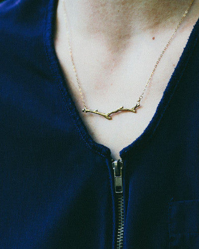 Model wearing gold tree branch necklace 